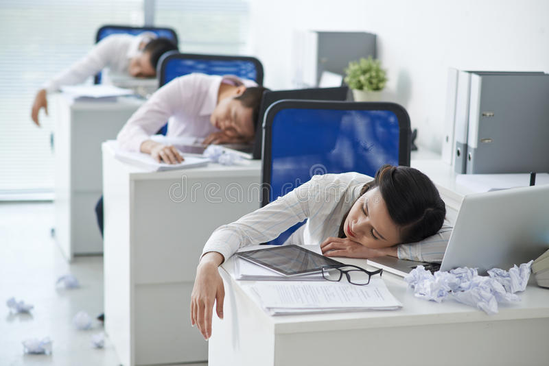 tired-office-workers-asian-business-people-sleeping-their-workplaces-66388363